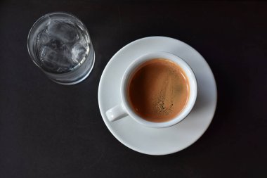 Sıcak kahve, masanın üzerindeki bardaktaki sade kahveydir. İçmeye hazırdır..