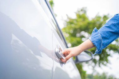 Kot giyen kadınlar arabanın kapısını açmak üzereler..