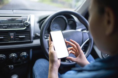Şoför araba sürerken telefonu kullanır. Model için izole ekran. Arka planda araba navigasyon görüntüsü.