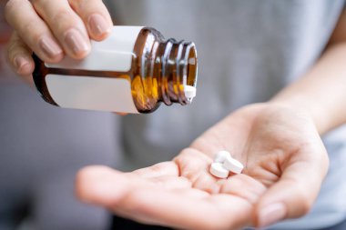 Elinde haplar olan bir kadın. Tıp ve sağlık hizmetleri kavramı. Sağlıklı yaşam tarzı, ilaç, besleyici maddeler ve insan konsepti