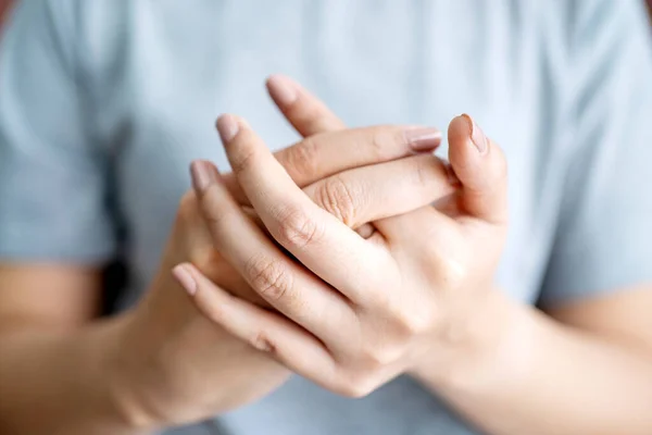 Woman suffering from hand and finger joint pain. Causes of rheumatoid arthritis, carpal tunnel syndrome, gout.