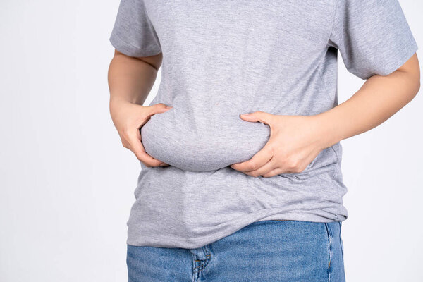 Fat woman, Fat girl, Fat belly, Chubby, woman's hand holding excessive belly fat isolated on white background. concept of surgery and subcutaneous fat breakdown.
