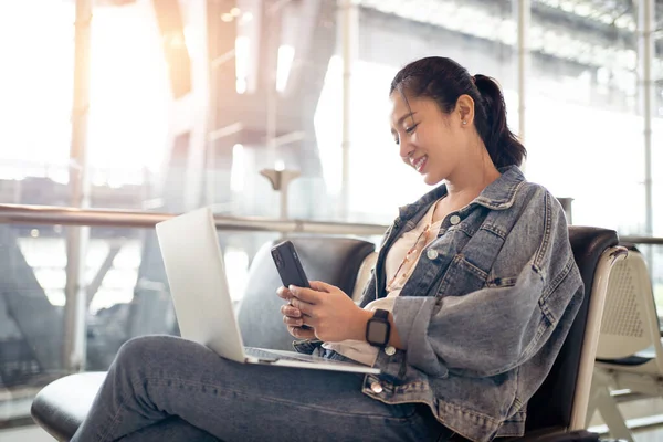 Νεαρή Ασιάτισσα Τουρίστρια Κοιτάζει Έξυπνο Τηλέφωνο Laptop Της Στο Αεροδρόμιο — Φωτογραφία Αρχείου