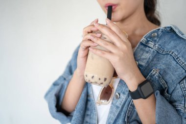 Buzlu sütlü çay içen Asyalı kadın.