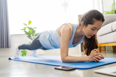 Young Asian healthy woman workout at home, she does pank