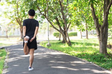 Asyalı koşucunun arkadan bakışı sabah parkta koşmak için ısınıyor..