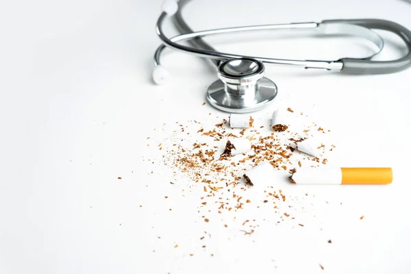 stock image Close up of broken pile cigarette or tobacco and doctor stethoscope on white background with copy space, health care concept. 