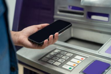 Arka planda bir Akıllı Telefon finansal işlemleri online tutan kadın, Atm kabine. Online Nfc Bankacılık Kavramı