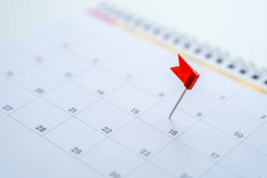 Bir takvim etkinlik planlayıcı takvimine işlenmiş kırmızı raptiyeler, iş toplantısı için planlama veya seyahat planlama kavramı.