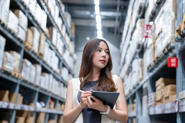 物流工場の棚の在庫状況を確認するアジアの女性ビジネスオーナー ストックフォト