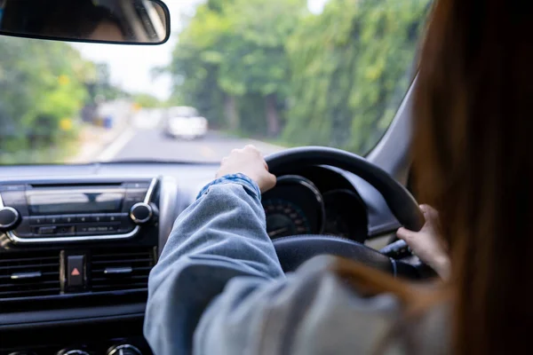 夏の旅行のための車を運転する女性のバックビュー 制御車のためのステアリング ホイールを握る運転者の手 安全運転コンセプト ロイヤリティフリーのストック画像