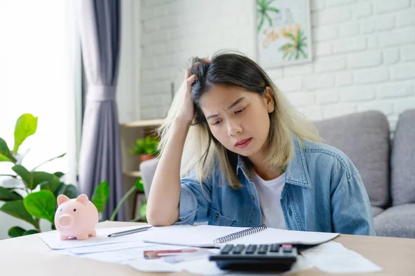 Depresyonda ve stresli Asyalı genç bir kadın finansal sorunlarla karşılaşıyor ve işsiz kaldıktan sonra kredi kartı faturasını ödeyecek parası yok. İflas kavramı.