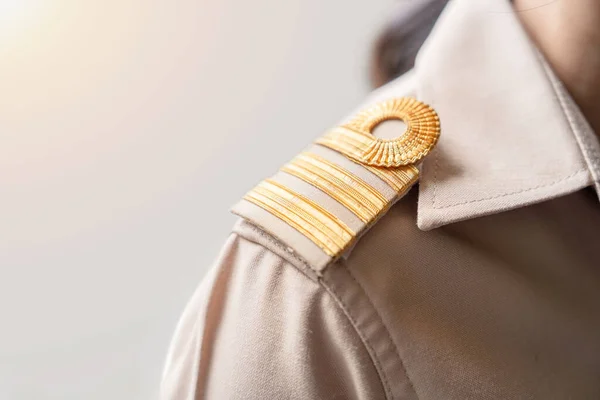 肩に金のストライプが付いている茶色の制服の写真 タイの公務員の制服 ストックフォト