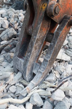 Yıkım alanındaki enkaz ve metalin arasında kazıcı pençesi.