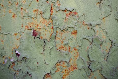 Çatlak diş minesi boyası ve pas lekeleri olan paslı demir bir zemin.