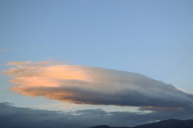 Gökyüzünde bulutlar ve dağlar olan bir panorama. 