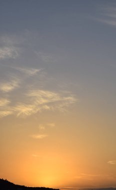 Gökyüzünde bulutlar ve dağlar olan bir panorama. 