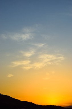 Gökyüzünde bulutlar ve dağlar olan bir panorama. 