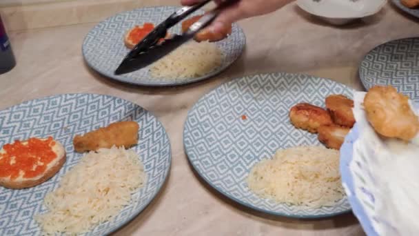 一个女人的手把面糊炸鱼放在厨房桌上的盘子里 — 图库视频影像