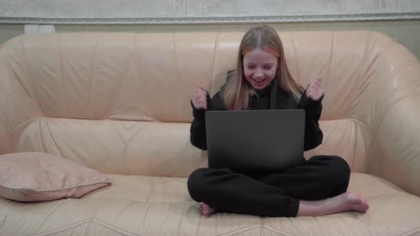Elinde Dizüstü Bilgisayarı Olan Genç Bir Kız Kanepeye Oturup Neşeli — Stok video