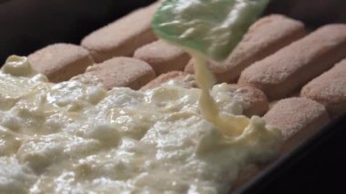 Tiramisu keki hazırlıyorum, önceden hazırlanmış kurabiyelere krema sürüyorum. Yakın plan...