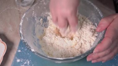 Women's hands knead the dough for making homemade pastries.