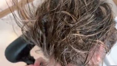 Women's hair close-up, dried with an electric hair dryer.