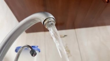 Water is running from an open faucet in the kitchen.