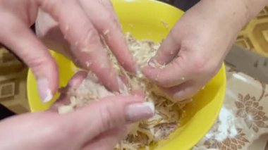 Kadınların elleri geleneksel bir et yemeği hazırlarken kaynamış kümes hayvanlarını ayırır..