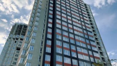 Mavi gökyüzüne karşı yapım aşamasındaki yüksek binaların manzarası.