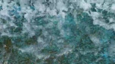 Suyun dokusu taş yüzeyde akıyor ve farklı yönlere sıçrıyor..