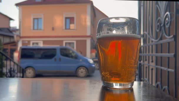 Stole Pozadí Rušné Ulice Stojí Sklenice Jantarového Piva Osvěžující Pivo — Stock video