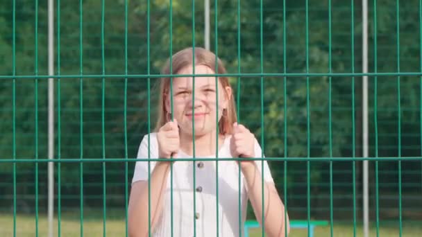 Een Jong Immigrant Meisje Achter Tralies Een Vluchtelingenkamp — Stockvideo