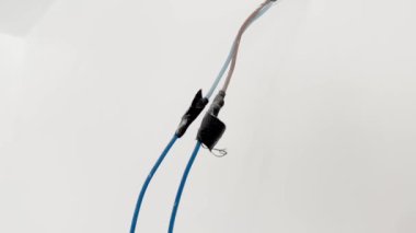 Tadilat sırasında beyaz bir duvardan uzun bir elektrik teli sarkıyor..