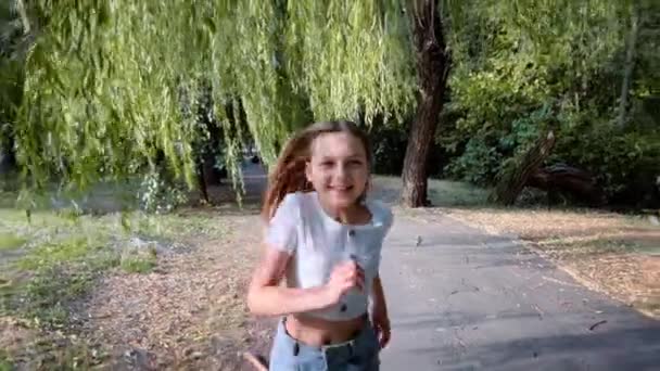 Девушка Радостной Улыбкой Бежит Через Парк Встретиться Камерой — стоковое видео