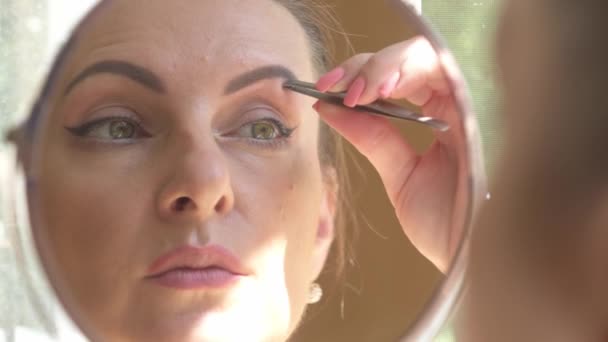 Middle Aged Woman Plucks Her Eyebrows While Looking Mirror Sun — Stock Video