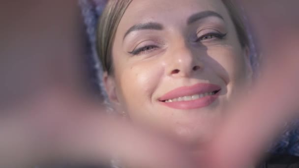 Neşeli Kadın Kalp Şeklinde Parmaklarıyla Kameraya Gülümsüyor — Stok video