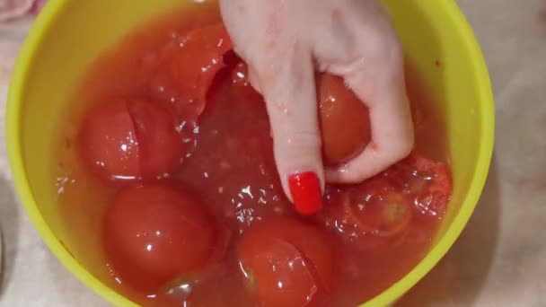 女性は自宅でソースを作るためにジュースを抽出するためにトマトを粉砕します — ストック動画