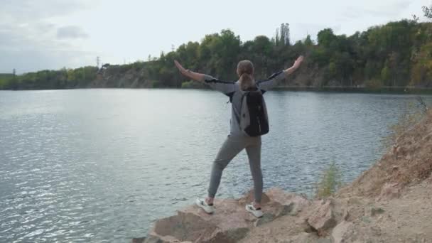 Kvinnlig Turist Med Ryggsäck Axlarna Står Toppen Rocky River Bank — Stockvideo