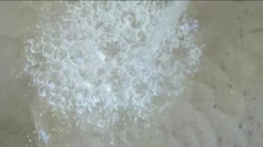 Su akışından yükselen su yüzeyindeki hava kabarcıkları.