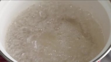 Su, mutfak sobasındaki metal tavada kaynıyor..