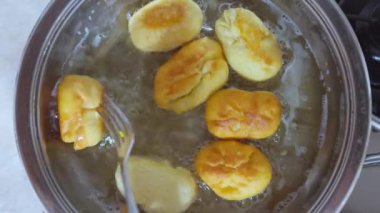 Ev yapımı kekleri kaynayan sebze yağında hazırlıyoruz. Aşçı çatalla turta yapar..