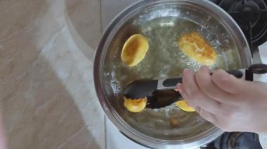 Kadın kaynar yağdan ev yapımı çörekleri alıyor..