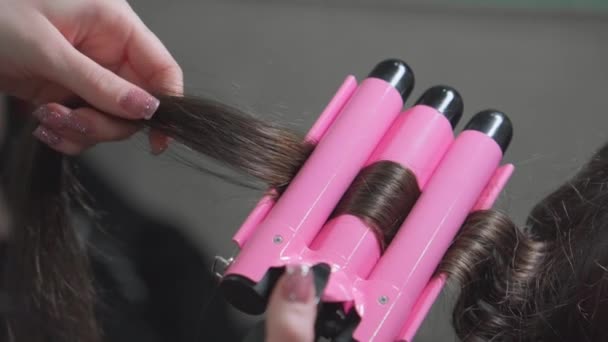 女性は電気カーリングアイロンを使用して彼女の友人の髪をカール — ストック動画