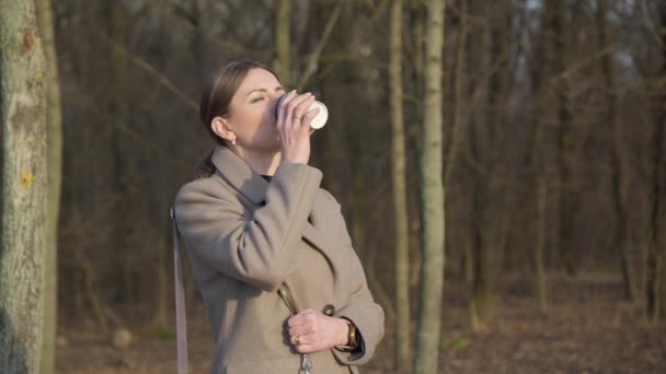 Женщина Средних Лет Легком Пальто Наслаждается Горячим Кофе Парке — стоковое видео