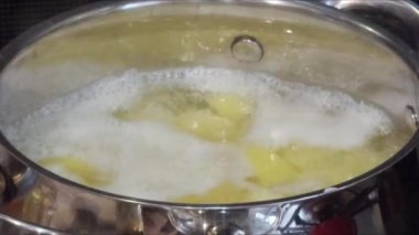 Köpüklü ve buharlı kaynar su tenceresi. Patates pişiriyorum. Tavadan buhar yükselir ve kabarcıklar yüzeyde yüzer...