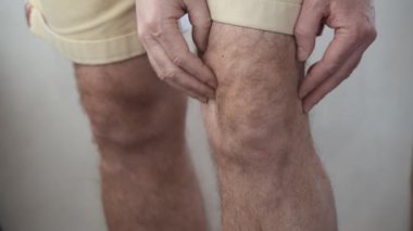 Adam yaralı dizine masaj yapıyor...