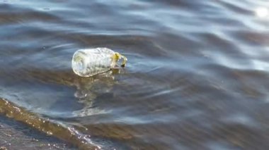 Kıyıya yakın su yüzeyine atılmış plastik şişe...