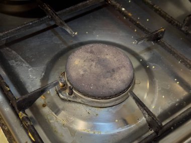Kirli metal yüzeyi olan, kullanıma hazır bir gaz ocağı...