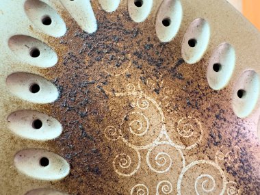 Görüntü, yanık izleri ve dekoratif deseni olan bir demir tabanı gösteriyor. Yüzeyde birden fazla buhar delikleri ve kararmış alanlar görülebilir...